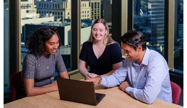 Photo of three people sitting at desk - 314x182px